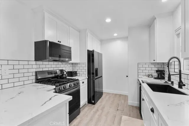 a kitchen that has a sink and a stove top oven