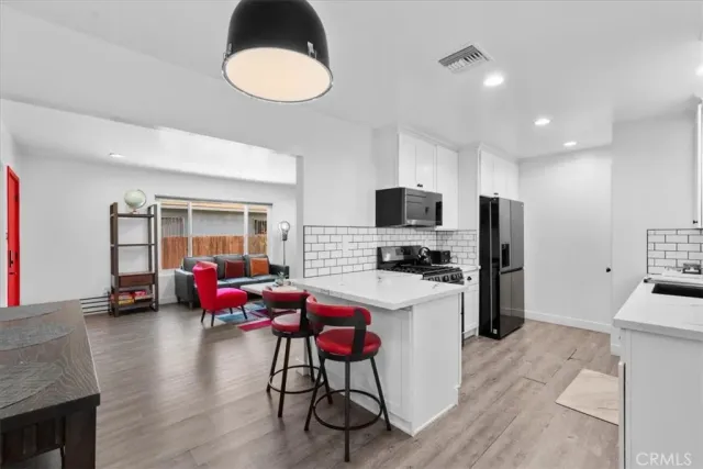 a kitchen with kitchen island a sink stainless steel appliances and cabinets