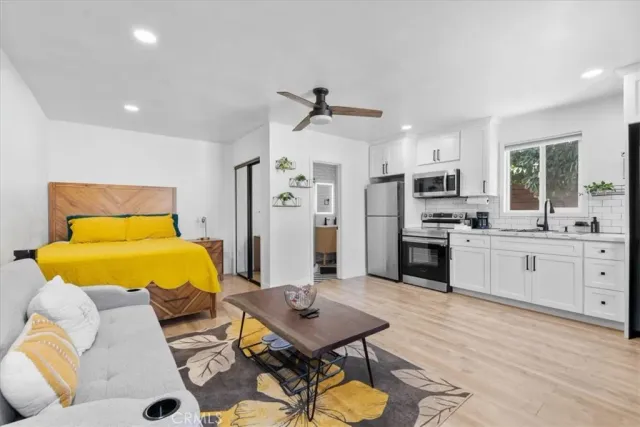 a kitchen with a refrigerator cabinets and wooden floor