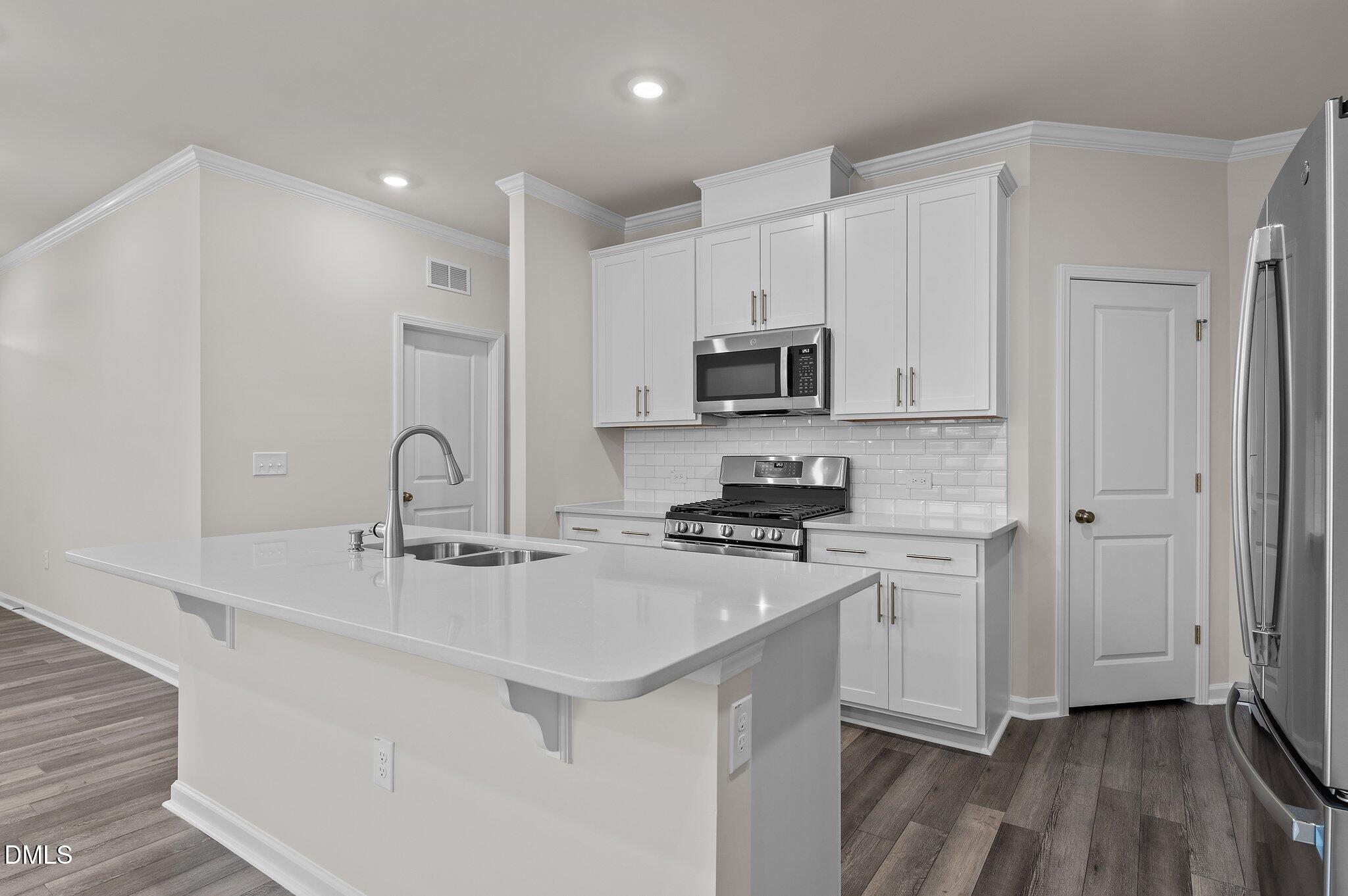 2202 Kasota Lane Raleigh, NC 27610 - Photo 26 of 79 a kitchen with stainless steel appliances a sink a stove a refrigerator and cabinets
