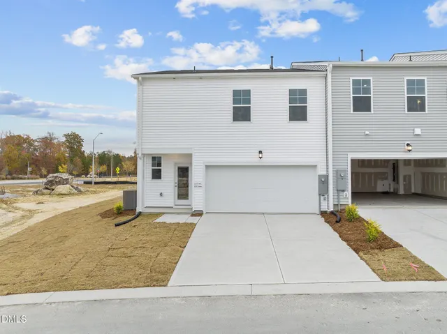 a view of a white building with a yard