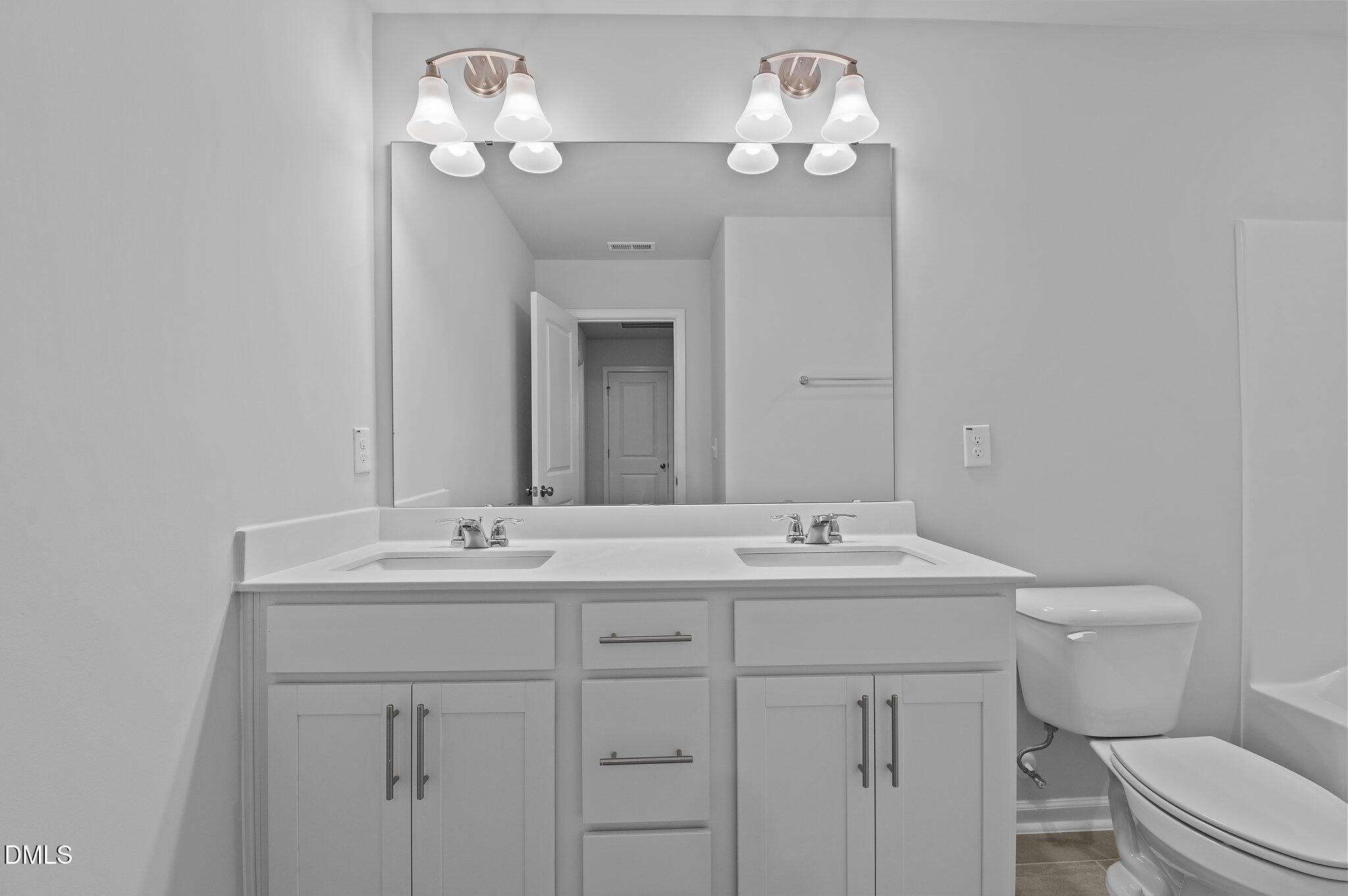2202 Kasota Lane Raleigh, NC 27610 - Photo 44 of 79 a bathroom with a toilet sink and mirror