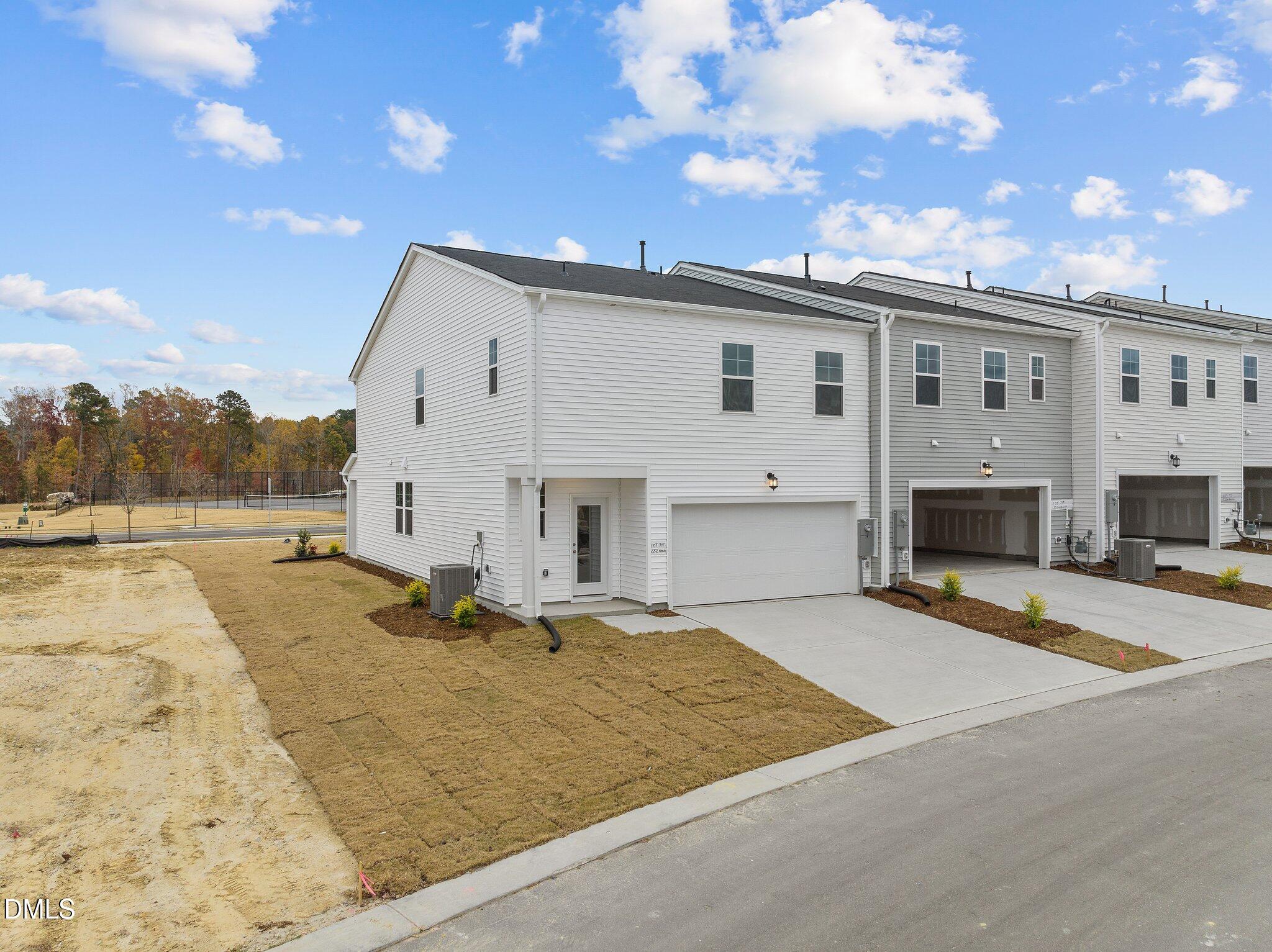 2202 Kasota Lane Raleigh, NC 27610 - Photo 5 of 79 a view of a white building with a yard