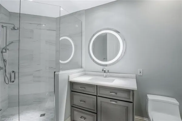 a bathroom with a sink a toilet and a mirror