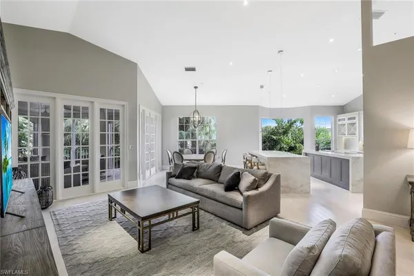 a living room with furniture potted plant and large windows