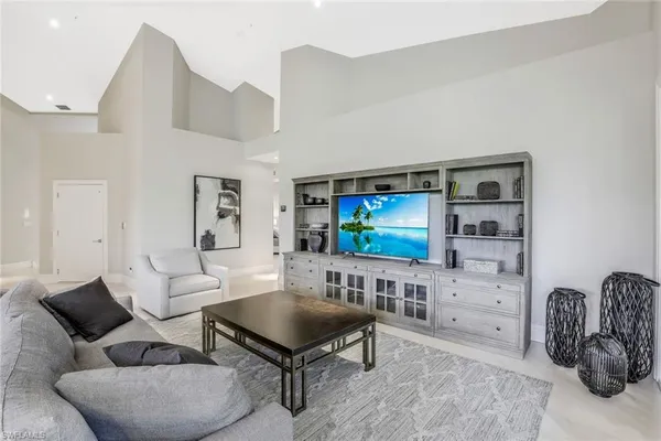 a living room with furniture a flat screen tv and kitchen view