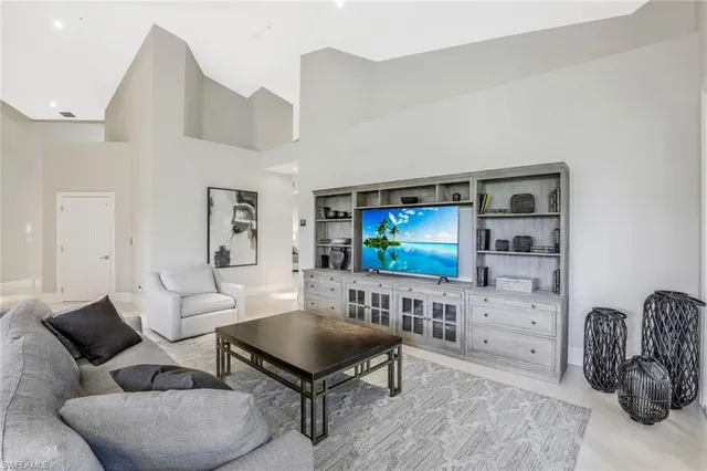 a living room with furniture a flat screen tv and kitchen view
