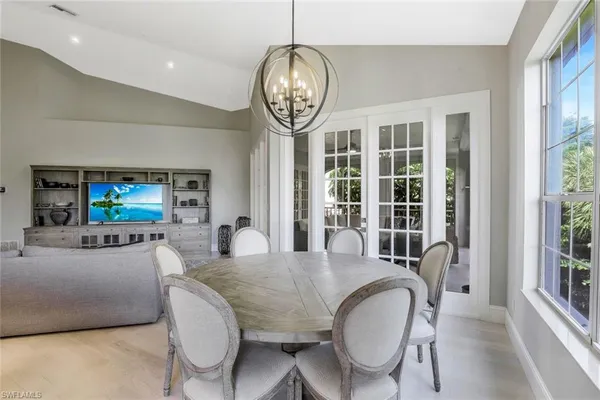 a dining room with furniture a chandelier and wooden floor