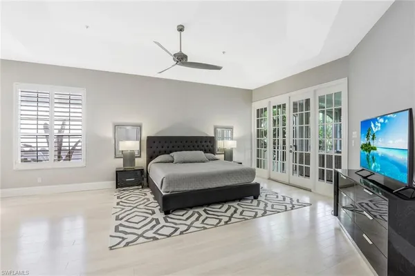 a bedroom with a bed and a flat tv screen on the dresser