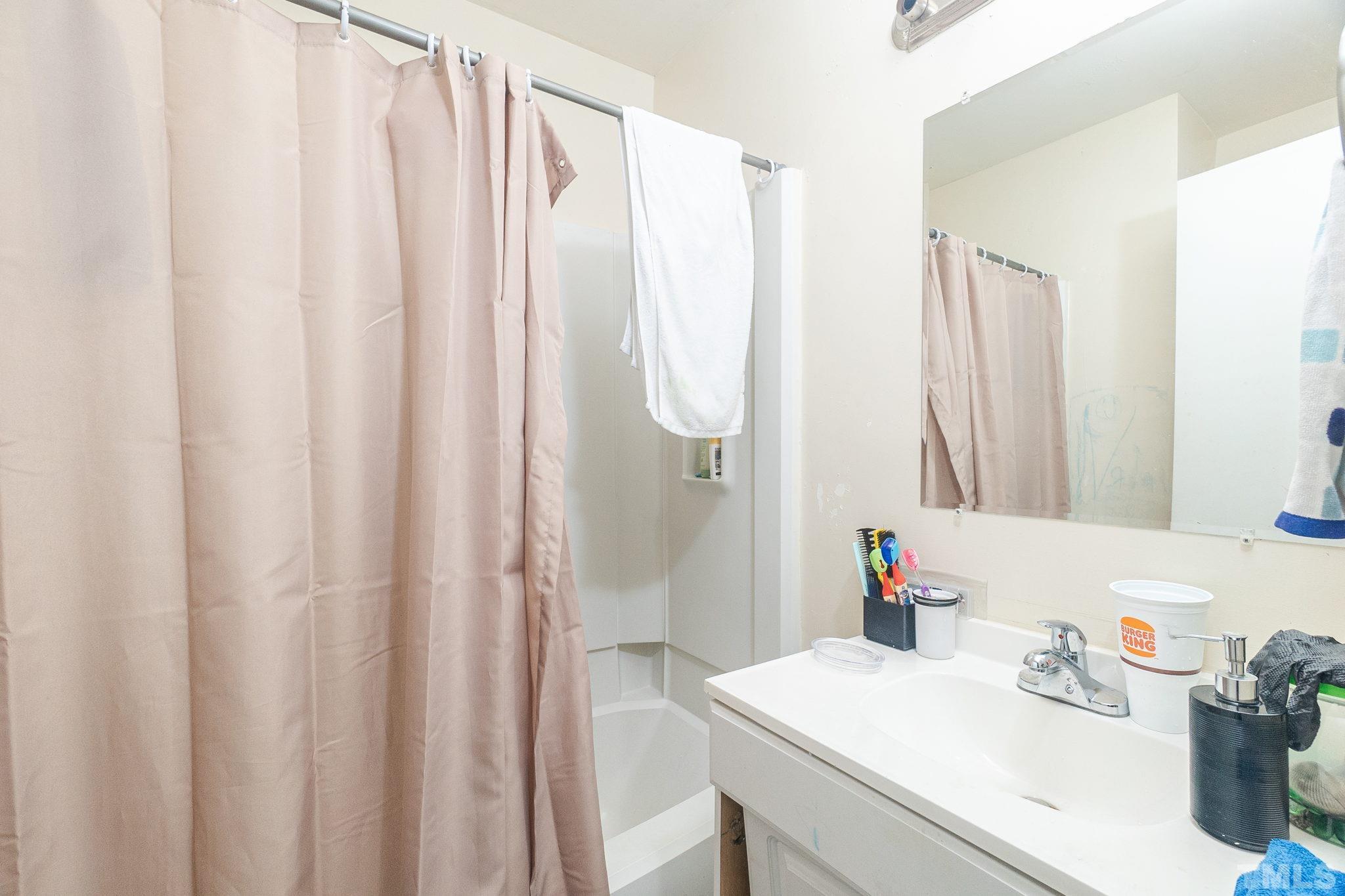 133 Bashford Road Raleigh, NC 27606 - Photo 23 of 45 a bathroom with a sink a mirror and a shower curtain