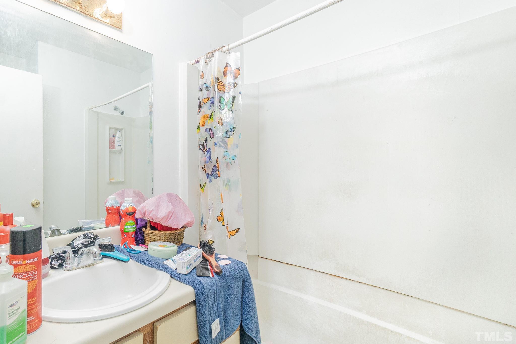 133 Bashford Road Raleigh, NC 27606 - Photo 32 of 45 a bathroom with a sink a mirror and a shower curtain
