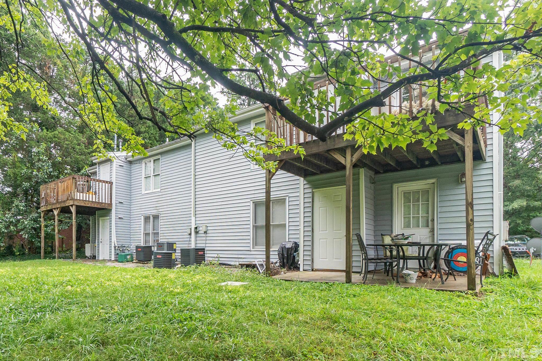 133 Bashford Road Raleigh, NC 27606 - Photo 42 of 45 a backyard of a house with lawn chairs and a large tree