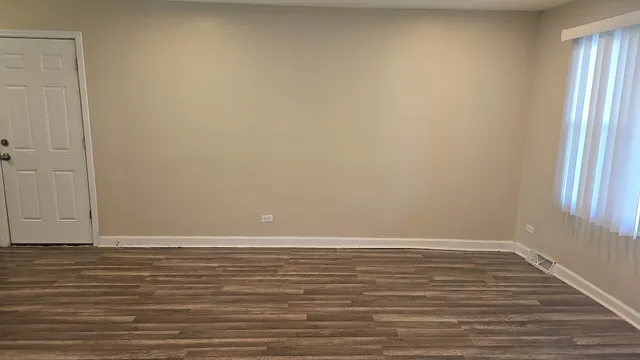a view of a room with wooden floor and window