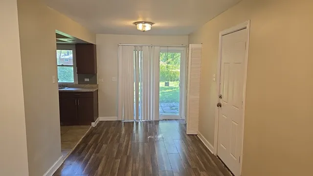 a view of a hallway with wooden floor and closet