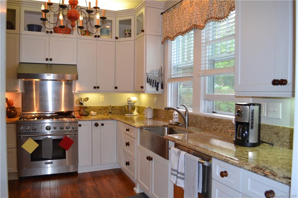 222 Maple Street Rutherfordton, NC 28139 - Photo 35 of 48 a kitchen with stainless steel appliances granite countertop a sink a stove and a wooden cabinets