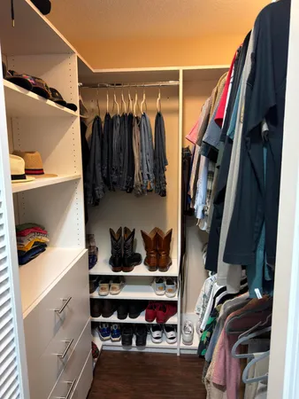 a view of walk in closet with clothes and shoes