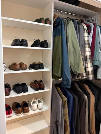a view of walk in closet with clothes and shoes