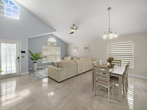 a living room with furniture a dining table and a chandelier