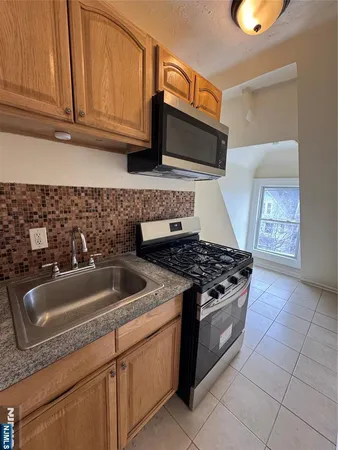 a kitchen with granite countertop a sink stove and cabinets