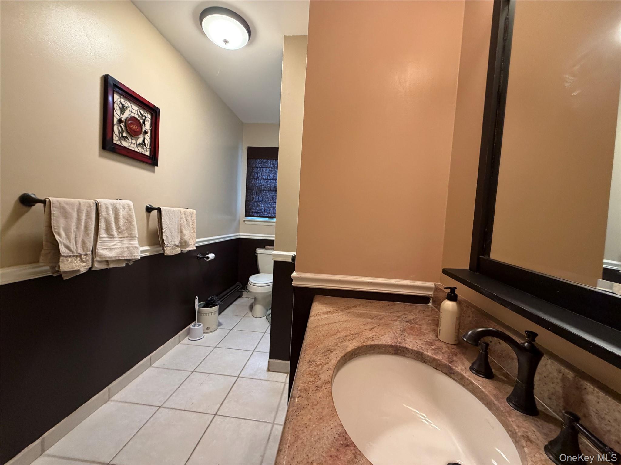 94 Booth Road Chester, NY 10918 - Photo 12 of 21 Hall bathroom featuring a vanity with a light-toned stone countertop and a dark-finished faucet