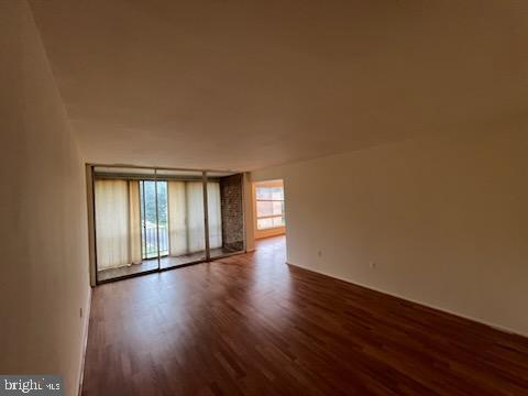 8489 Greenbelt Road, Unit 202 Greenbelt, MD 20770 - Photo 4 of 10 a view of an empty room with wooden floor and a window