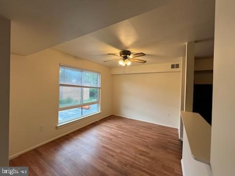 8489 Greenbelt Road, Unit 202 Greenbelt, MD 20770 - Photo 5 of 10 a view of an empty room with wooden floor and a window