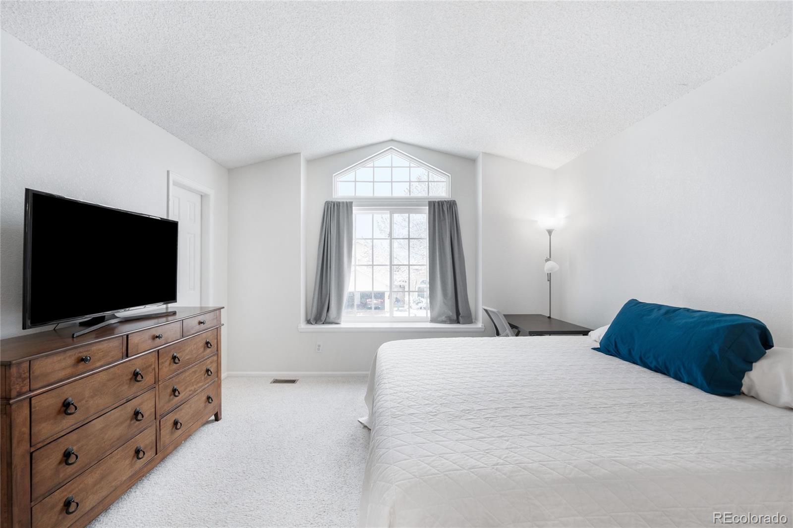 4132 South Jebel Way Aurora, CO 80013 - Photo 16 of 36 a bedroom with a bed and a flat screen tv