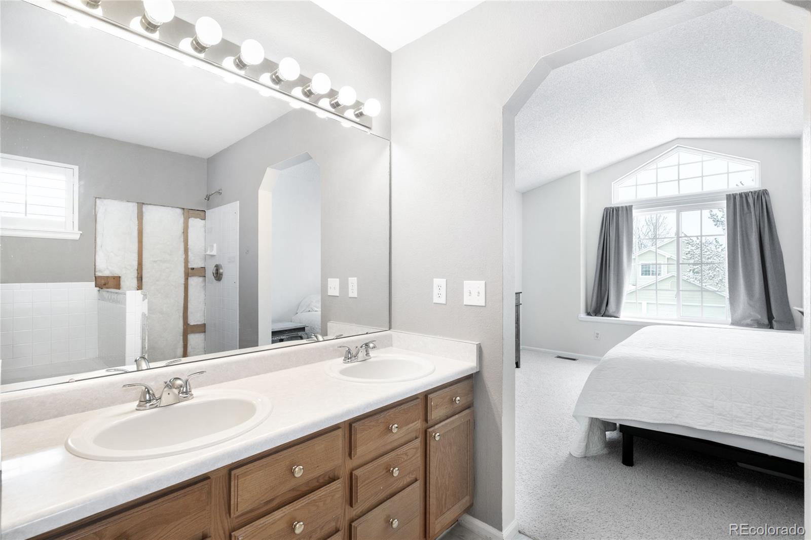 4132 South Jebel Way Aurora, CO 80013 - Photo 19 of 36 a en suite bathroom with a double vanity sink and a mirror