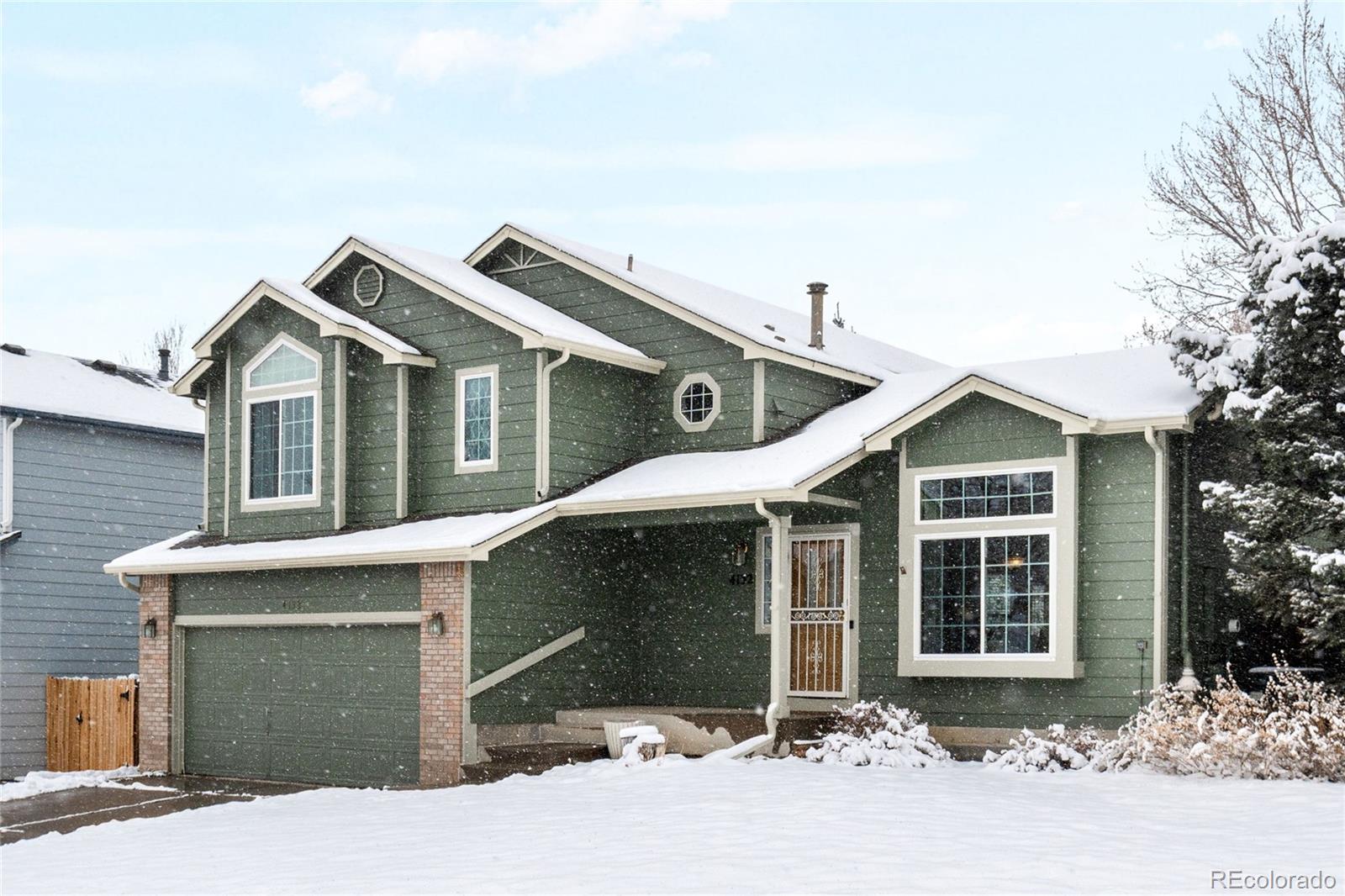 4132 South Jebel Way Aurora, CO 80013 - Photo 2 of 36 a front view of a house with a yard and garage