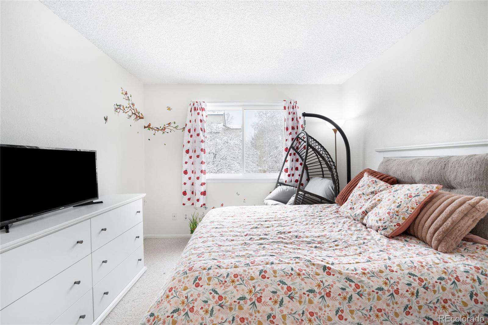 4132 South Jebel Way Aurora, CO 80013 - Photo 22 of 36 a bedroom with a bed and a flat screen tv