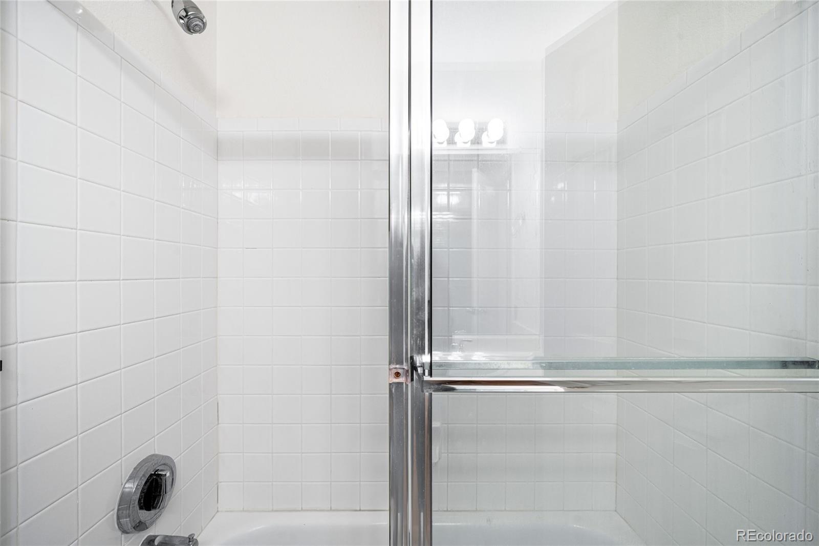 4132 South Jebel Way Aurora, CO 80013 - Photo 26 of 36 a bathroom with a glass shower door