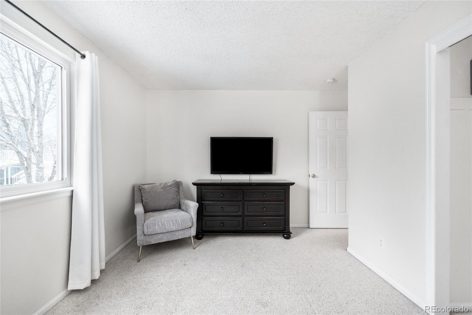 4132 South Jebel Way Aurora, CO 80013 - Photo 27 of 36 a living room with furniture and a flat screen tv