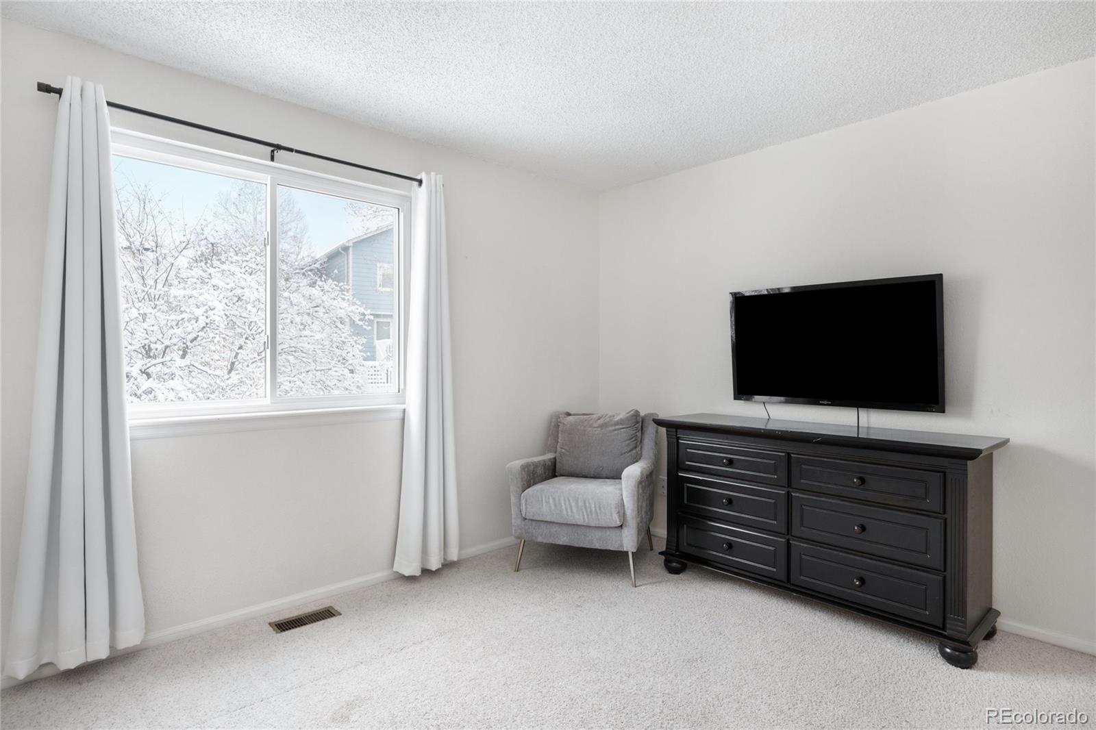 4132 South Jebel Way Aurora, CO 80013 - Photo 28 of 36 a living room with furniture and a flat screen tv