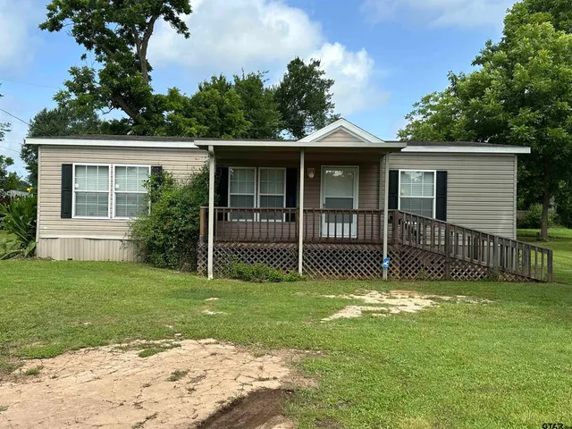 a view of a house with a yard and a garden