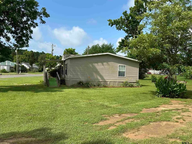 a backyard of a house with lots of green space and garden
