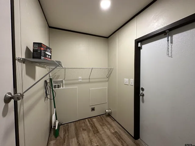 a view of storage and utility room with wooden floor