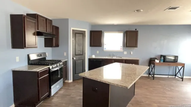a kitchen with a stove a refrigerator and a sink