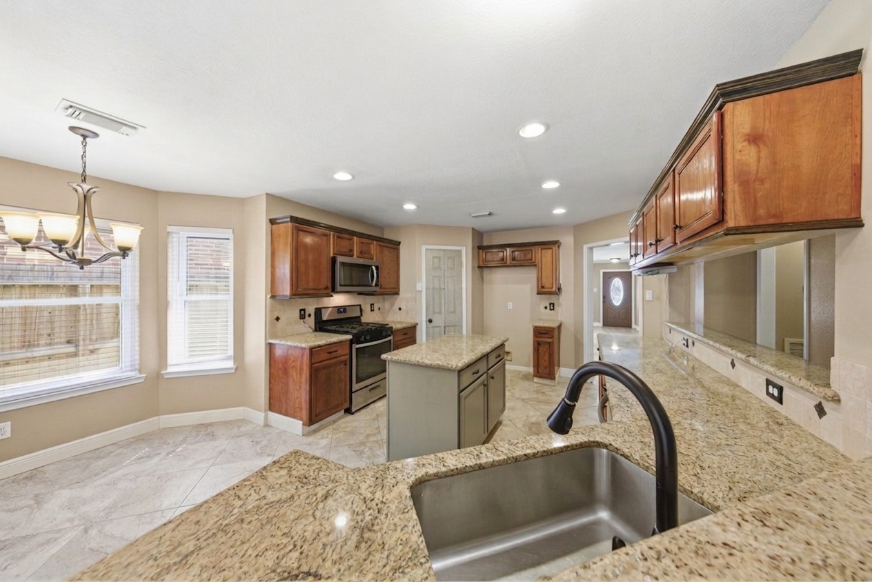 13506 Spring Court Tomball, TX 77375 - Photo 10 of 37 a kitchen with a stove a sink and a refrigerator