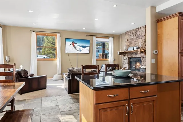 a kitchen with stainless steel appliances granite countertop a sink dishwasher stove and couches with wooden floor