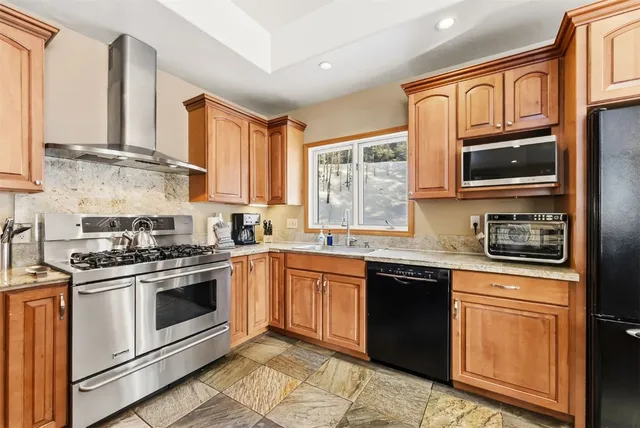 a kitchen with stainless steel appliances granite countertop a stove sink microwave and cabinets