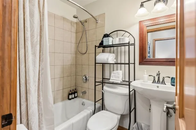 a bathroom with a sink toilet and shower