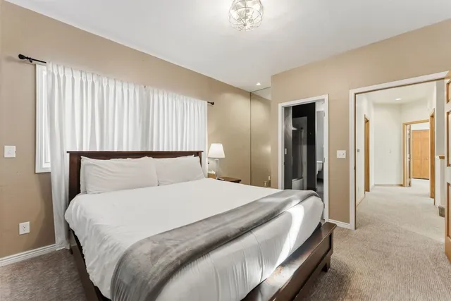 a bedroom with a large bed and a chandelier