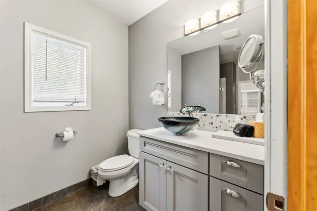 a bathroom with a toilet sink and mirror
