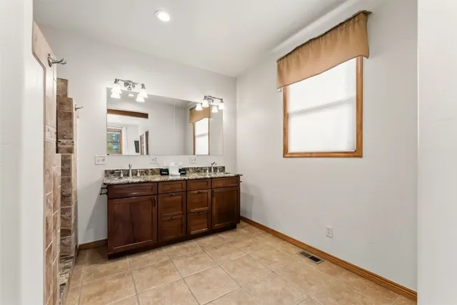 a large bathroom with a tub sink and mirror