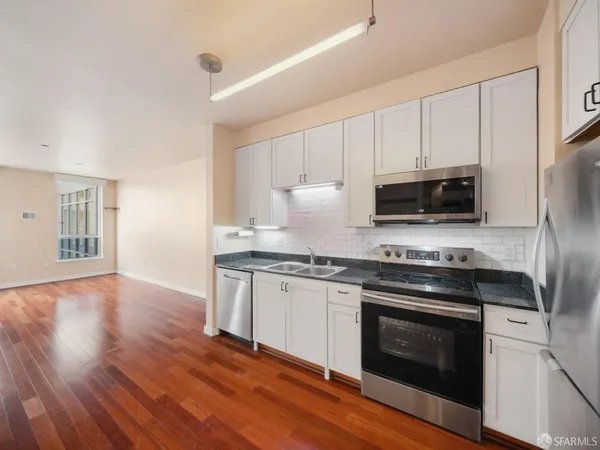 a kitchen with granite countertop wooden floors and stainless steel appliances