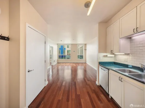 a kitchen with wooden floors and white cabinets