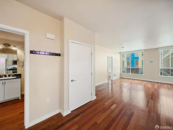a view of a hardwood floor in an empty room with a window