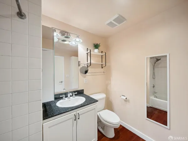 a bathroom with a sink a toilet and mirror