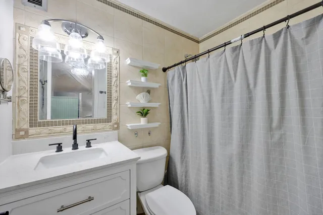 a bathroom with a sink mirror and a toilet