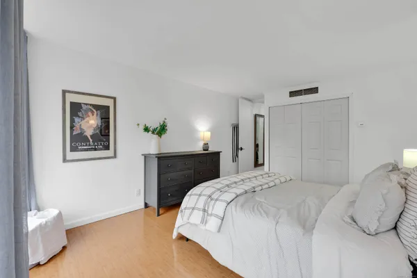 a bedroom with a bed and a painting on the wall